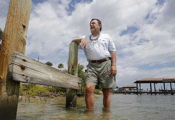 Clay Henderson stands in the Indian River